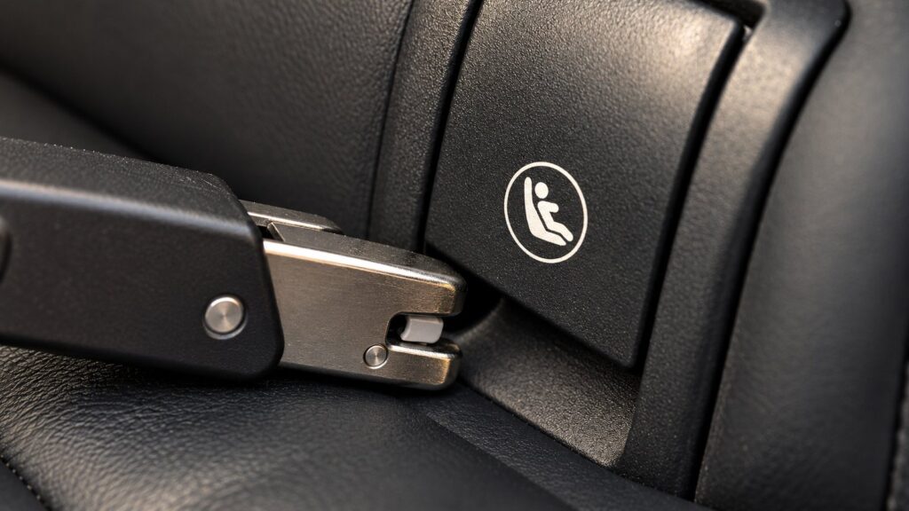 ISOFIX connector approaching the anchorage in a car seat gap